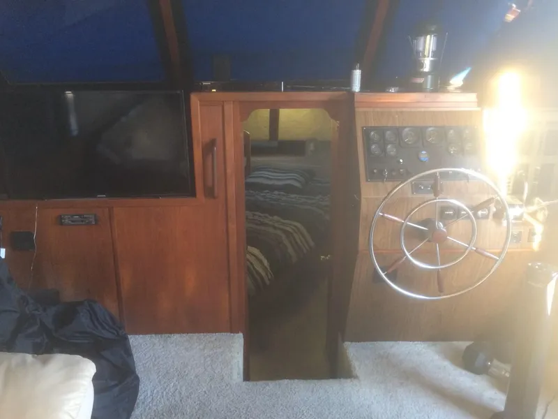 Slide: The Image of 1985 Bluewater 42 Coastal Cruiser interior with helm, wooden paneling, and cozy cabin entrance. - 19
