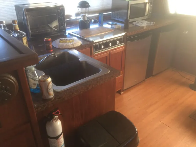 Slide: The Image of Kitchen area of 1985 Bluewater 42 Coastal Cruiser with appliances and wooden cabinetry. - 22