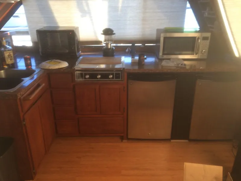 Slide: The Image of 1985 Bluewater 42 Coastal Cruiser kitchen with wooden cabinets, appliances, and countertop. - 23