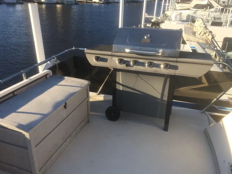 Slide: The Image of 1985 Bluewater 42 Coastal Cruiser deck with grill and storage box, docked by the water. - 3