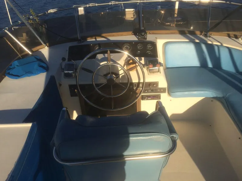 Slide: The Image of Helm of 1985 Bluewater 42 Coastal Cruiser with blue seating and steering wheel. - 4