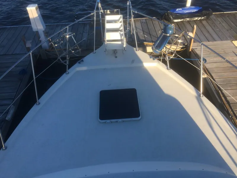 Slide: The Image of 1985 Bluewater 42 Coastal Cruiser docked, showing bow deck and marina setting. - 6