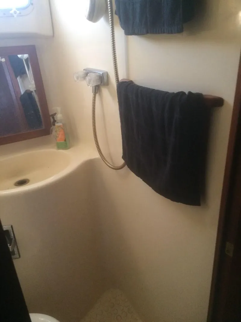 Slide: The Image of 1985 Bluewater 42 Coastal Cruiser bathroom with sink, towel, and showerhead. - 9