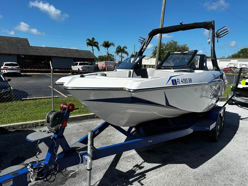 Slide: The Image of 2018 Axis A20 boat on trailer, parked outdoors under clear blue sky. - 15