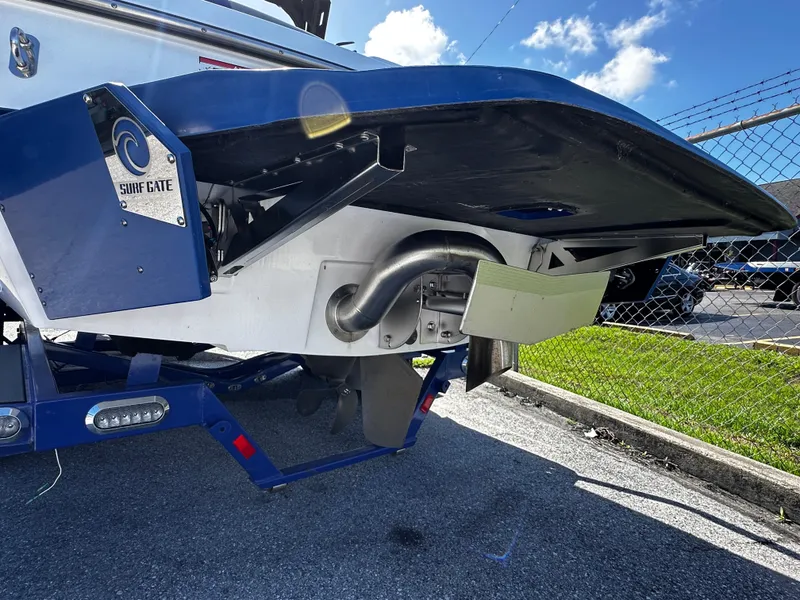 Slide: The Image of 2018 Axis A20 boat with Surf Gate system, parked on pavement under blue sky. - 19