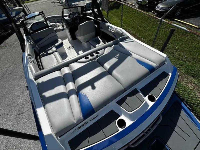 Slide: The Image of 2018 Axis A20 boat interior with gray and blue seating, parked outdoors. - 21