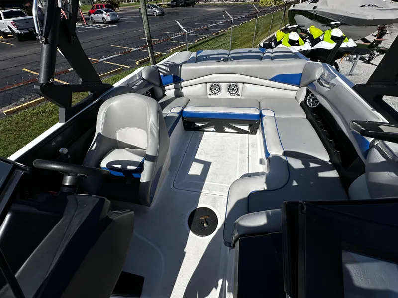 Slide: The Image of 2018 Axis A20 boat interior with seating and steering wheel, parked outdoors. - 24