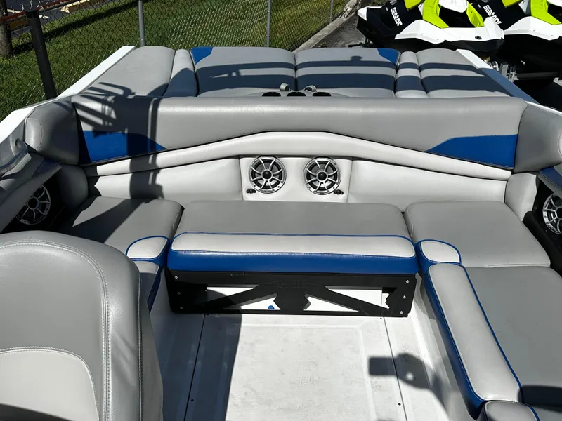 Slide: The Image of 2018 Axis A20 boat interior with gray and blue seating, featuring built-in speakers. - 25