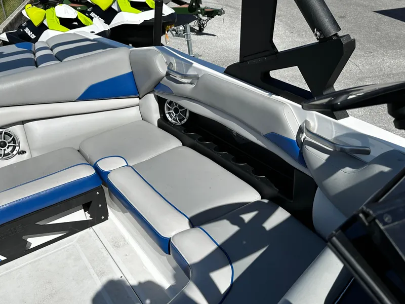 Slide: The Image of 2018 Axis A20 boat interior with gray and blue seating, featuring built-in speakers. - 26