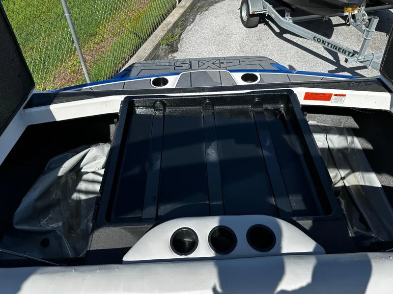 Slide: The Image of 2018 Axis A20 boat interior with storage compartment and cup holders. - 32