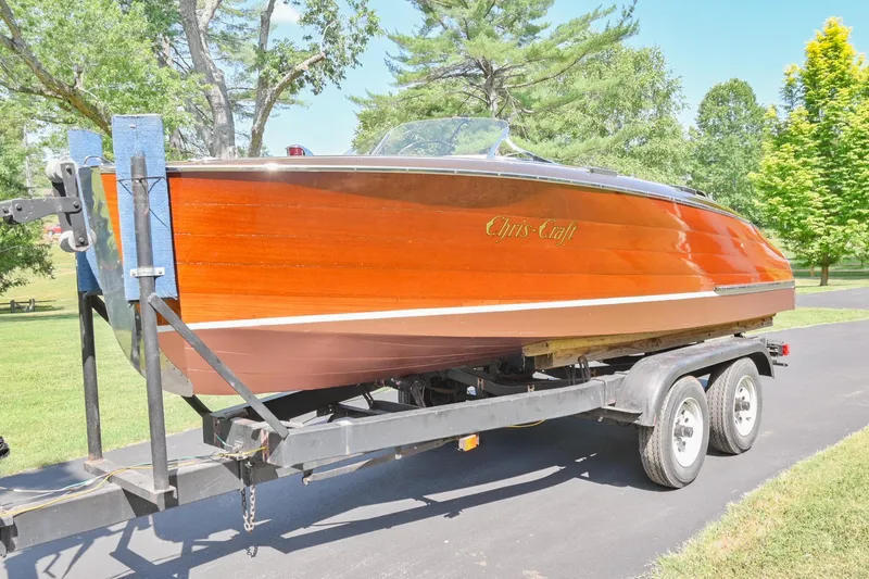 Slide: The Image of 1942 Chris-Craft 17 wooden boat on a trailer in a park setting. - 29