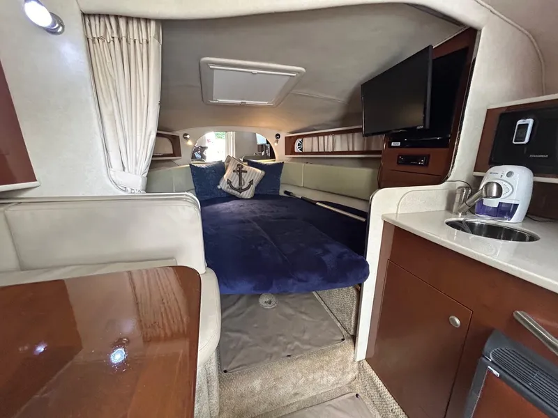 Slide: The Image of Interior of 2008 Sea Ray 280DA boat with cozy cabin, bed, and kitchenette. - 11