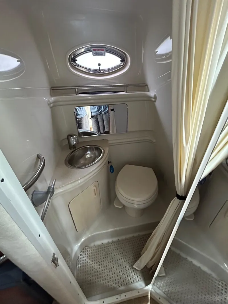 Slide: The Image of 2008 Sea Ray 280DA boat bathroom with sink, toilet, and porthole window. - 14