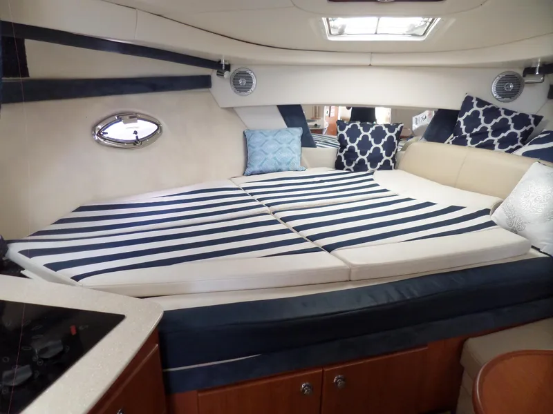 Slide: The Image of 2008 Bayliner 320 Express cabin interior with striped bedding and decorative pillows. - 29