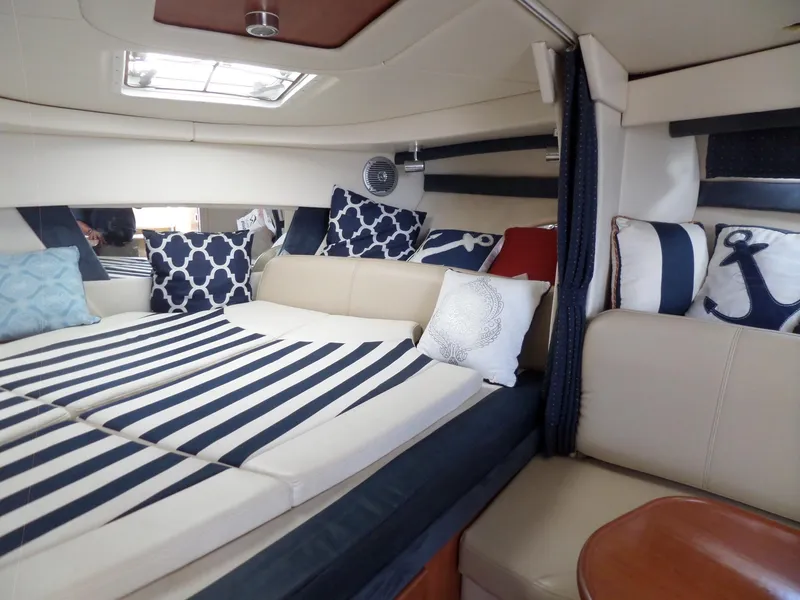 Slide: The Image of Interior cabin of 2008 Bayliner 320 Express with striped bedding and nautical-themed pillows. - 30