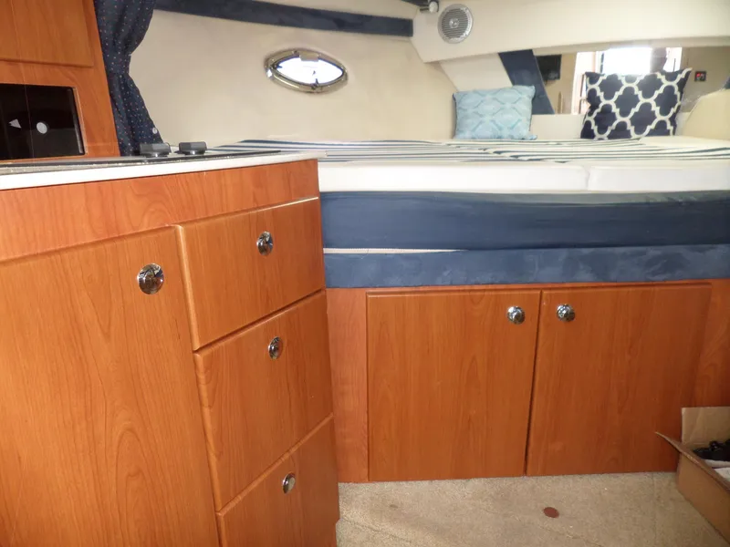 Slide: The Image of 2008 Bayliner 320 Express cabin interior with wooden cabinets and bed. - 31