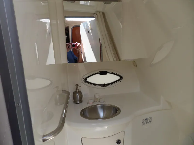 Slide: The Image of 2008 Bayliner 320 Express bathroom with sink, mirror, and porthole window. - 43