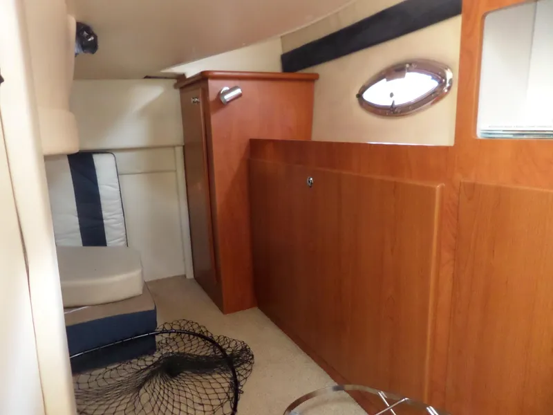 Slide: The Image of Interior cabin of a 2008 Bayliner 320 Express boat with wooden cabinetry and seating. - 46