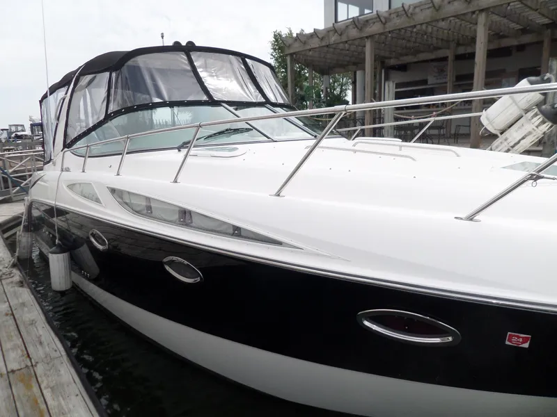 Slide: The Image of 2008 Bayliner 320 Express boat docked at marina, featuring sleek black and white design. - 5
