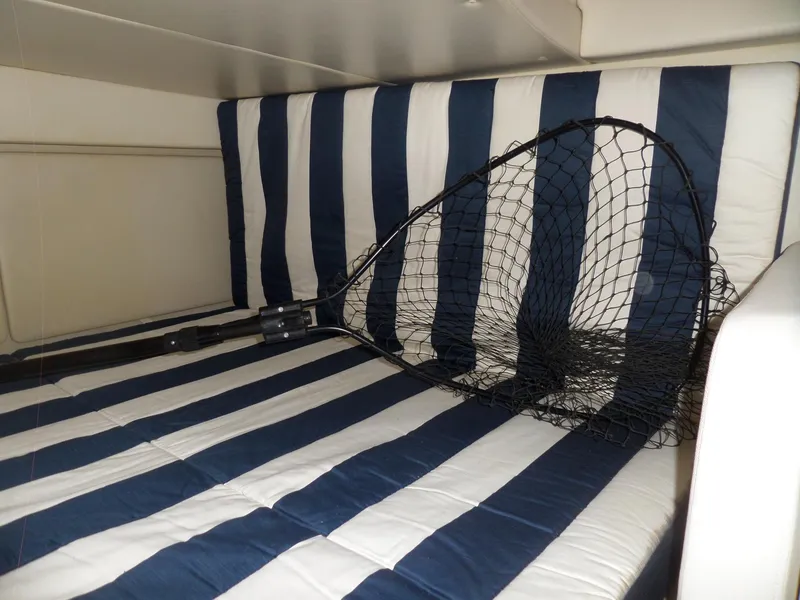 Slide: The Image of Fishing net on striped cushion in 2008 Bayliner 320 Express cabin. - 50