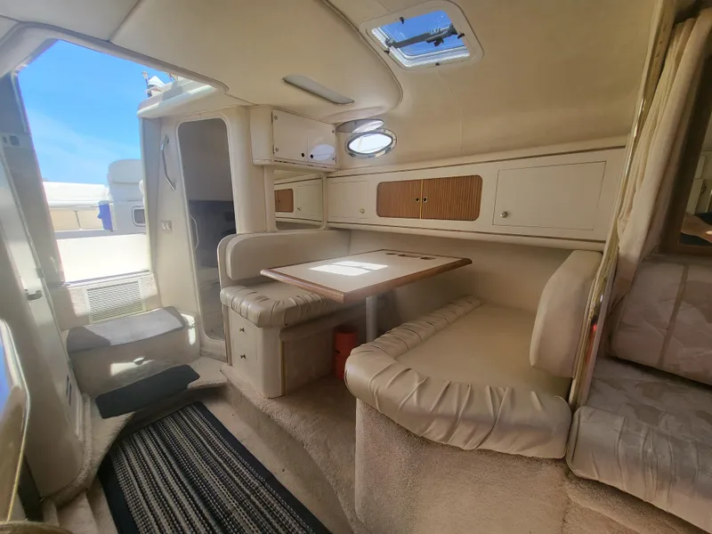 Slide: The Image of Interior of 1999 Sea Ray 290 Sundancer boat with cozy seating and table. - 12