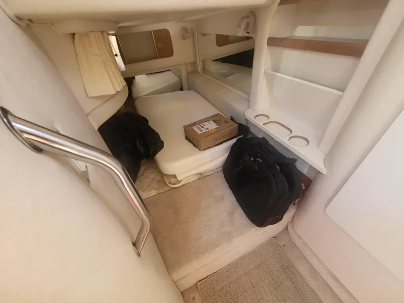 Slide: The Image of 1999 Sea Ray 290 Sundancer cabin interior with storage and seating area. - 14