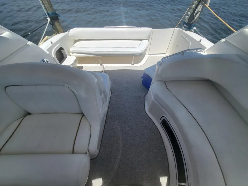 Slide: The Image of 1999 Sea Ray 290 Sundancer boat interior with white seating and carpeted floor. - 18
