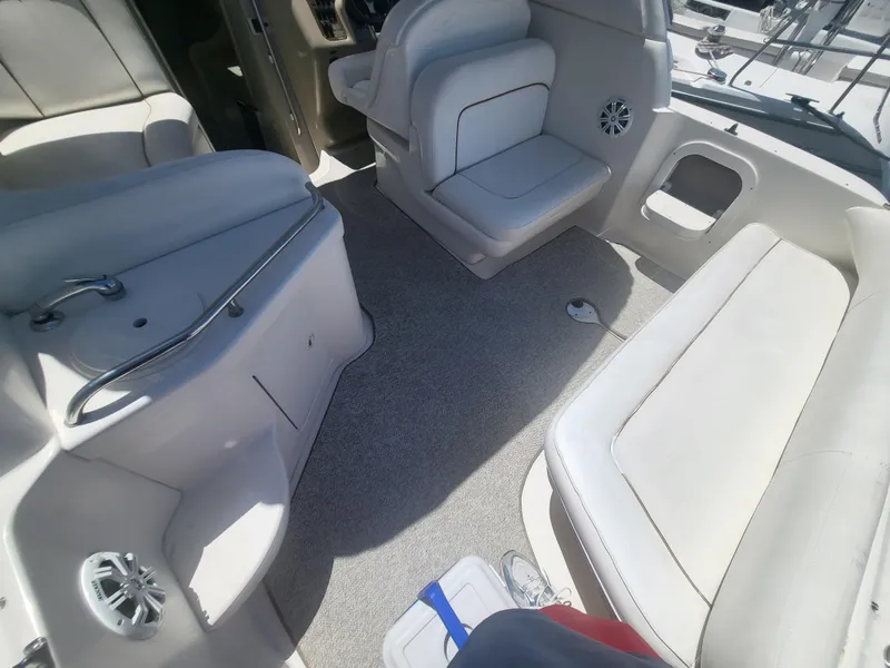 Slide: The Image of 1999 Sea Ray 290 Sundancer boat interior with beige seating and carpeted floor. - 20