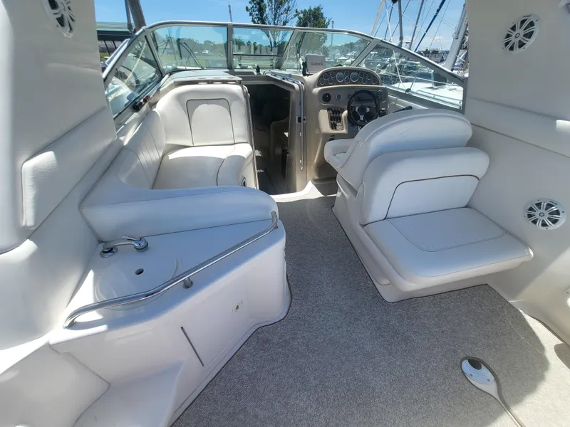 Slide: The Image of 1999 Sea Ray 290 Sundancer boat interior with white seating and steering console. - 21