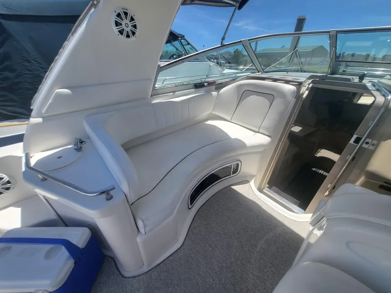 Slide: The Image of 1999 Sea Ray 290 Sundancer boat interior with white seating and cabin entrance. - 22