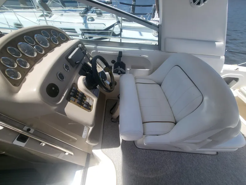 Slide: The Image of 1999 Sea Ray 290 Sundancer helm with white captain's seat and instrument panel. - 24