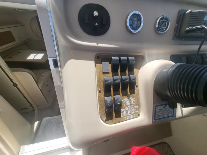 Slide: The Image of Control panel of a 1999 Sea Ray 290 Sundancer boat, featuring switches and gauges. - 31