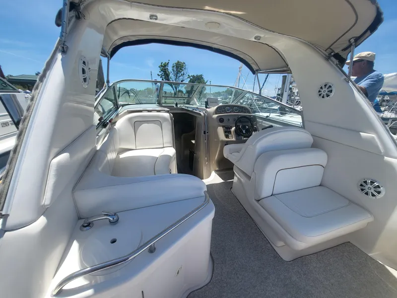 Slide: The Image of 1999 Sea Ray 290 Sundancer boat interior with white seating and dashboard. - 4