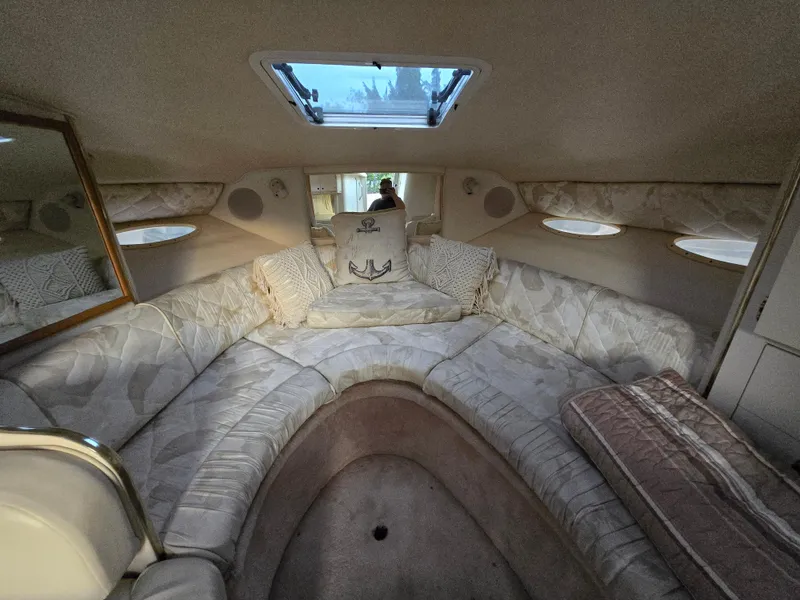 Slide: The Image of 1999 Sea Ray 290 Sundancer cabin interior with plush seating and skylight. - 41