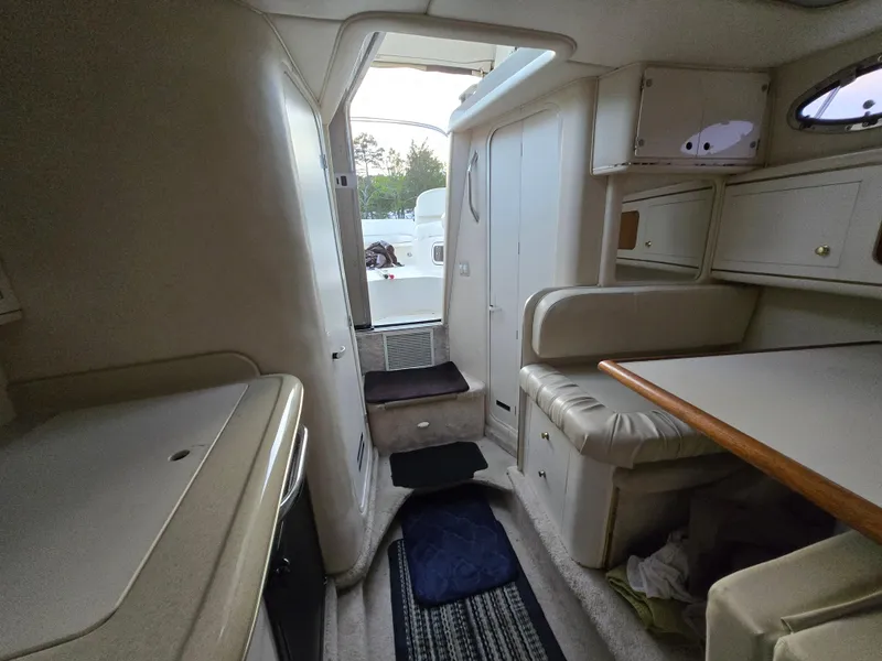 Slide: The Image of Interior of 1999 Sea Ray 290 Sundancer boat, featuring seating and cabinetry. - 43