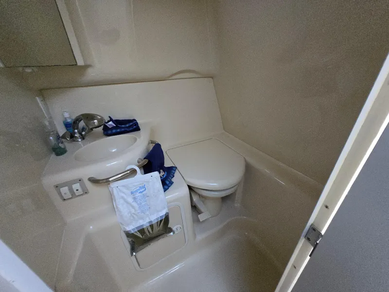 Slide: The Image of 1999 Sea Ray 290 Sundancer bathroom with sink, toilet, and storage. - 44