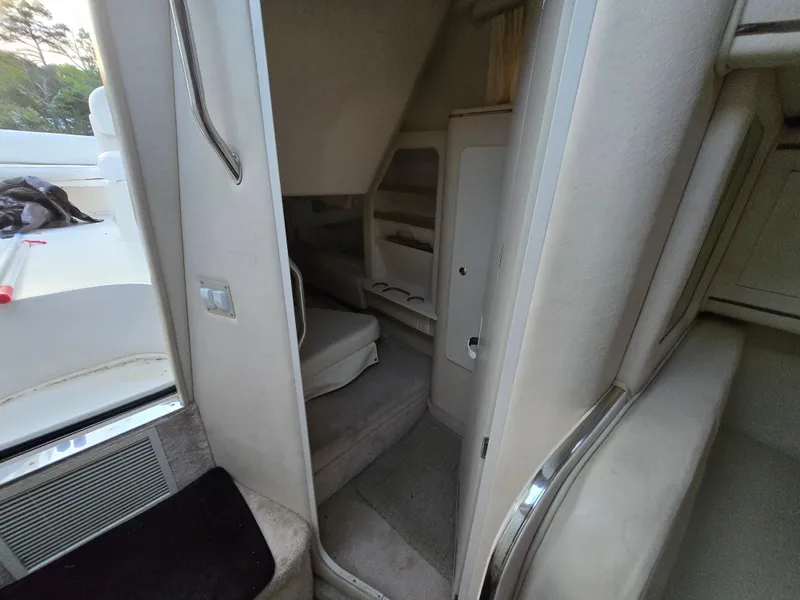 Slide: The Image of 1999 Sea Ray 290 Sundancer cabin interior with seating and storage. - 45