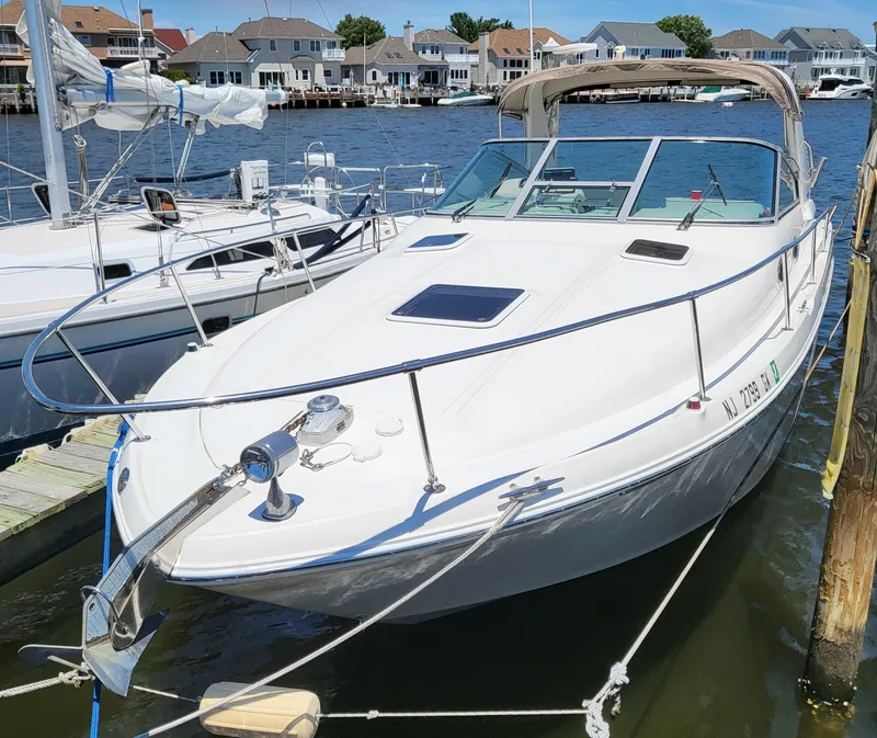 Slide: The Image of 1999 Sea Ray 290 Sundancer docked at marina, surrounded by water and houses. - 5