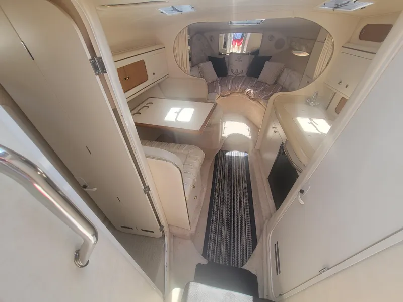 Slide: The Image of 1999 Sea Ray 290 Sundancer cabin interior with seating, table, and kitchenette. - 6