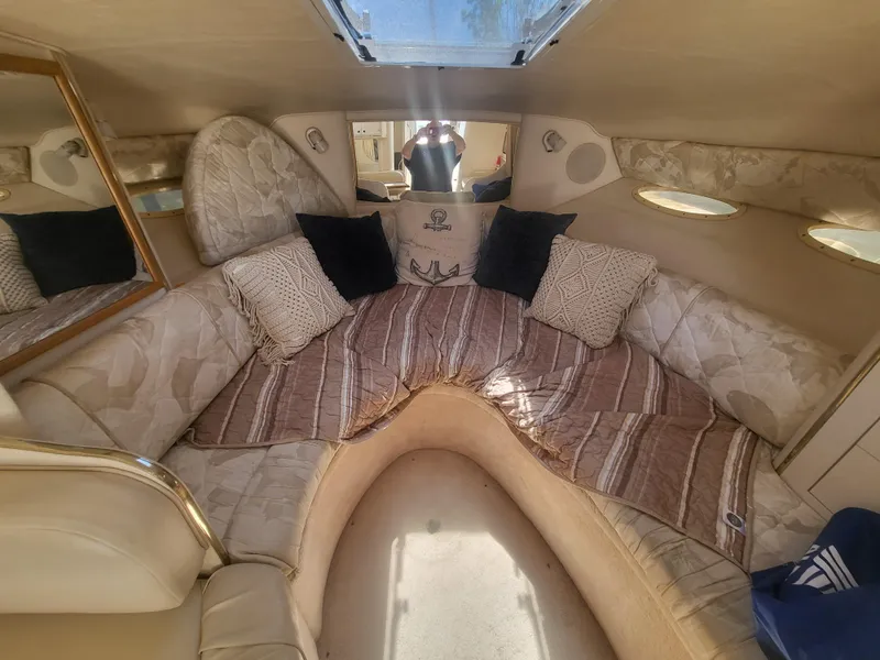 Slide: The Image of 1999 Sea Ray 290 Sundancer cabin interior with cozy seating and decorative pillows. - 7