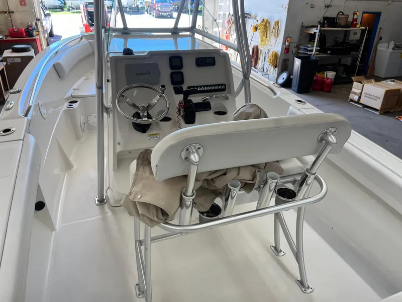 Slide: The Image of 2015 Sailfish 220 boat interior with steering console and seating in a garage setting. - 13