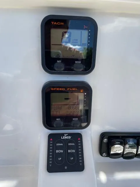 Slide: The Image of 2015 Sailfish 220 boat dashboard with tachometer, speed fuel gauge, and Lenco trim tab controls. - 15