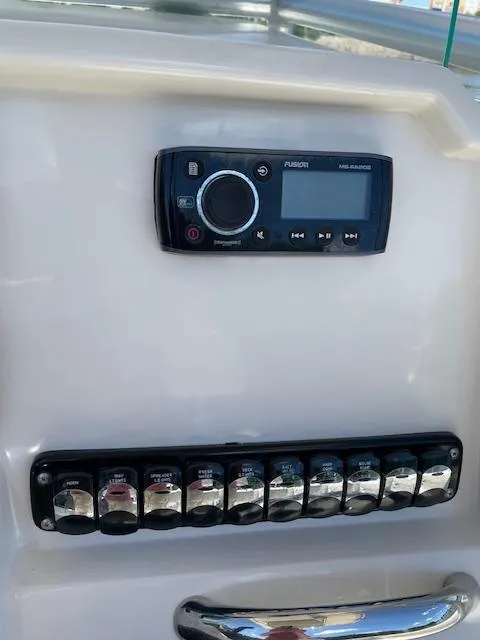 Slide: The Image of Control panel of a 2015 Sailfish 220 boat with audio system and switches. - 14