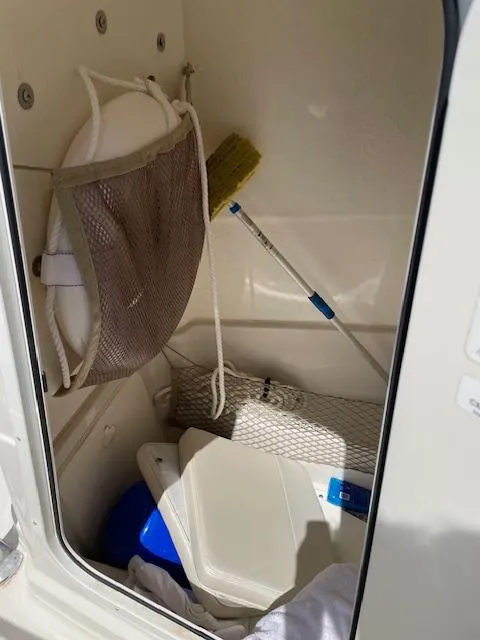 Slide: The Image of Storage compartment of 2015 Sailfish 220 boat with cleaning supplies and life preserver. - 18