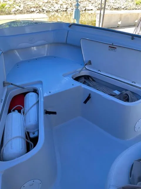 Slide: The Image of 2015 Sailfish 220 boat interior with open storage compartments and safety equipment. - 22