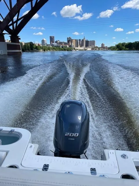 Slide: The Image of 2015 Sailfish 220 boat cruising under bridge with city skyline in background. - 7