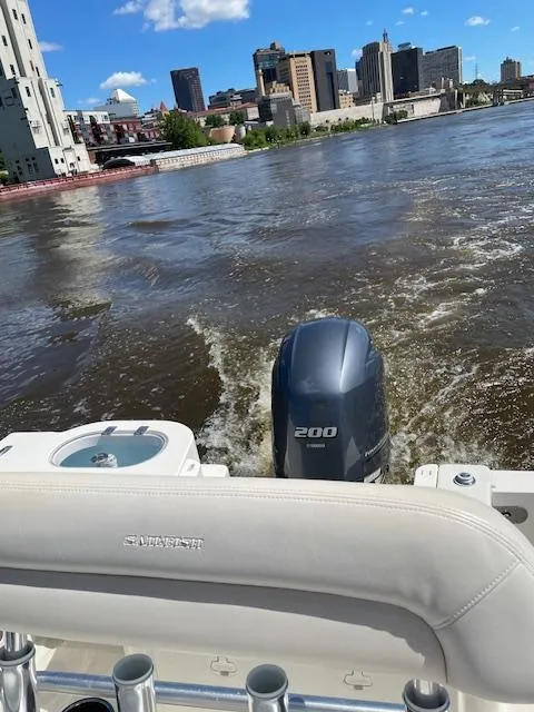 Slide: The Image of Sailfish 220 boat on river, city skyline in background, clear blue sky. - 8