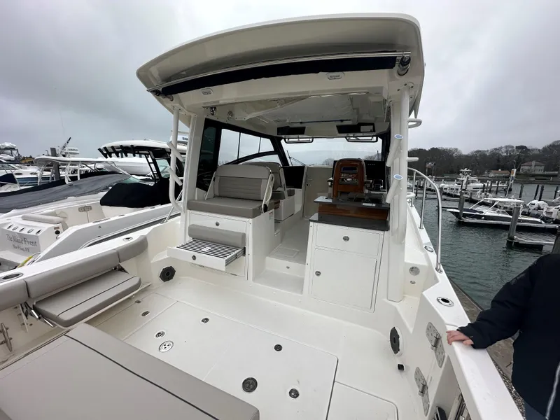 Slide: The Image of 2025 Boston Whaler 365 Conquest boat interior at marina, showcasing seating and helm area. - 12