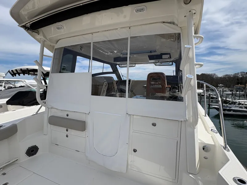 Slide: The Image of 2025 Boston Whaler 365 Conquest boat with enclosed cockpit, docked at marina. - 13
