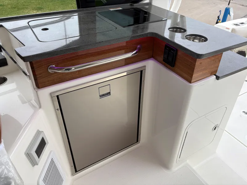 Slide: The Image of 2025 Boston Whaler 365 Conquest boat galley with sleek countertop and storage. - 14